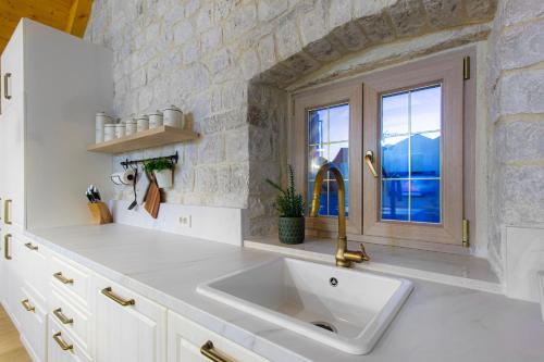 a white kitchen with a sink and a window at House Marijeta and Tonka in Trogir