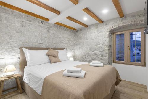 a bedroom with a large bed with towels on it at House Marijeta and Tonka in Trogir