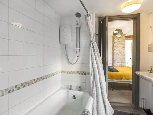 a white bathroom with a tub and a sink at The Cottage in Gorleston-on-Sea