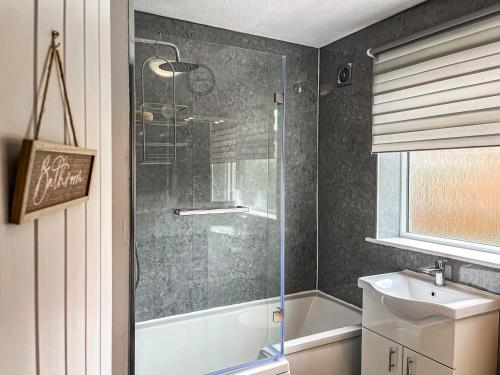 a bathroom with a shower and a sink at Pennies Retreat in Glossop