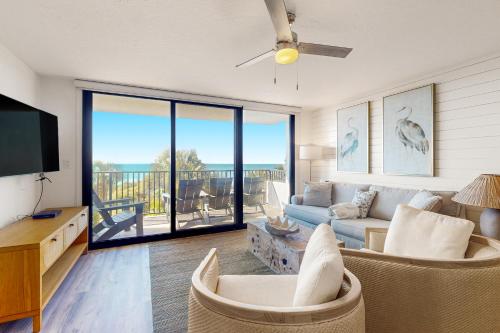 a living room with a couch and a tv at One Seagrove Place 0206 in Santa Rosa Beach