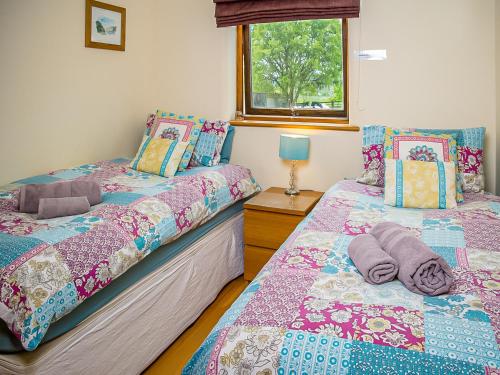Duas camas sentadas uma ao lado da outra num quarto em Bramble Barn em Tortworth