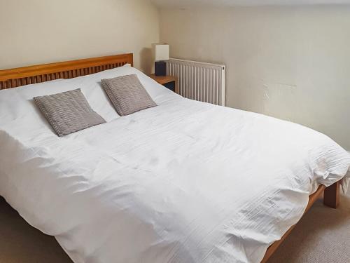 ein großes weißes Bett mit zwei Kissen darauf in der Unterkunft Market Place in Workington