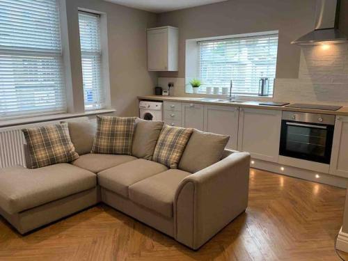 a living room with a couch and a kitchen at Central Skipton - Devonshire Court Apartment 2 in Skipton