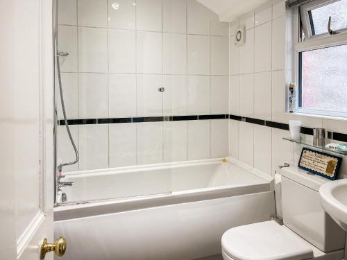a bathroom with a tub and a toilet and a sink at Beech Cottage - Uk44731 in Hartington