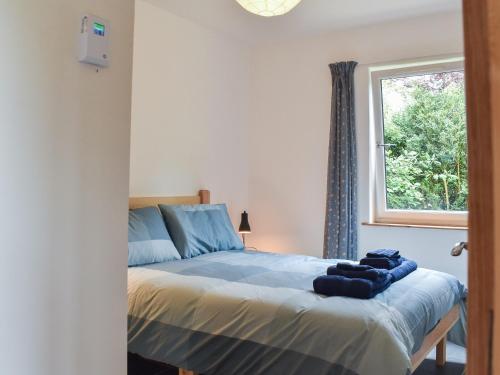 a bedroom with a bed and a window at Bridge Cottage in Earlston