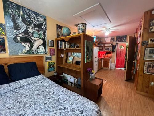 a bedroom with a bed and a book shelf at Miami Bungalow Oasis near Everglades & The Keys in Cutler Bay