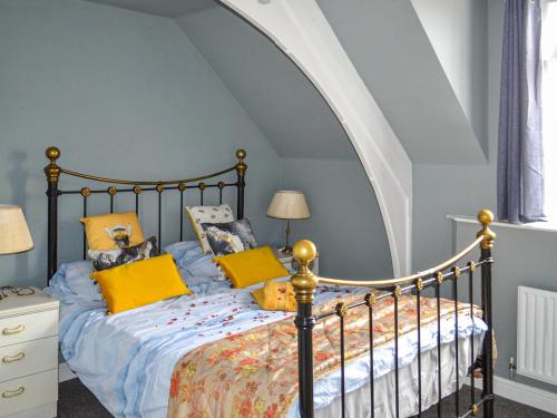 - une chambre avec un lit et des oreillers jaunes dans l'établissement The Old School, à Cleethorpes