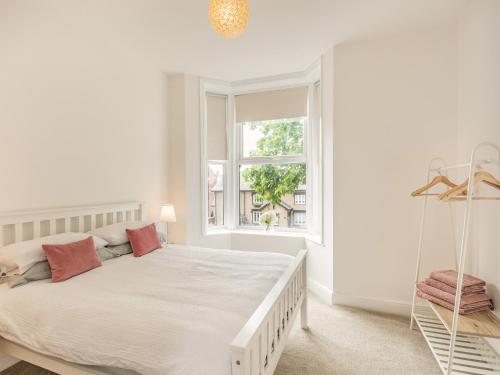 a white bedroom with a large bed and a window at Clifton Apartment - Uk42845 in Lytham St Annes