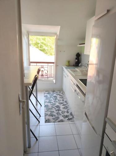 une cuisine avec un escalier menant à une fenêtre dans l'établissement Charme appartement entier près Paris La Défense Nanterre, à Suresnes