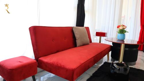 a red couch in a living room with a table at Modern Valentina Studio - Chic Masdar Retreat in Abu Dhabi