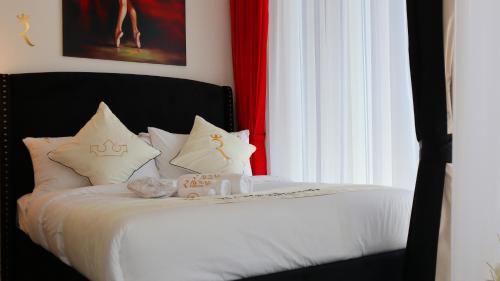 a bedroom with a bed with white sheets and pillows at Modern Valentina Studio - Chic Masdar Retreat in Abu Dhabi