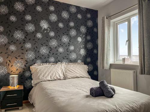 a bedroom with a bed with a black and white wallpaper at Regent House in Leek