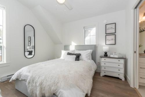 - une chambre blanche avec un grand lit blanc et une commode dans l'établissement Guest House Getaway - 1 Bdrm 1 Bath Carriage Home, à Chilliwack