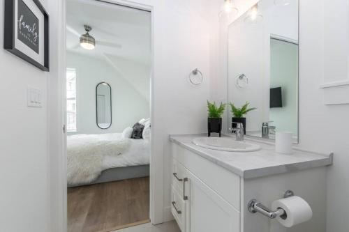 - une salle de bains blanche pourvue d'un lavabo et d'un lit dans l'établissement Guest House Getaway - 1 Bdrm 1 Bath Carriage Home, à Chilliwack