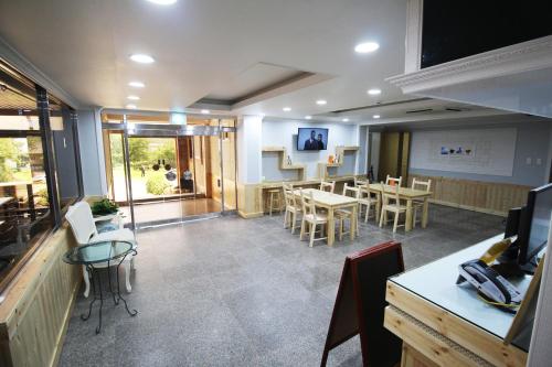 a room with a classroom with tables and chairs at The Red House in Sokcho