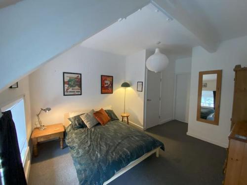 a bedroom with a bed and a table and a mirror at Biophilic Duplex - Family & Pet Friendly in Sheffield