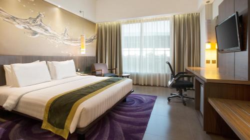 a hotel room with a bed and a desk at Holiday Inn Bandung Pasteur by IHG in Bandung