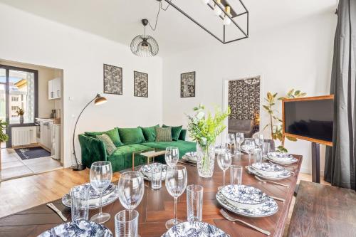 een woonkamer met een tafel en een groene bank bij Apartment Botanika in Wenen