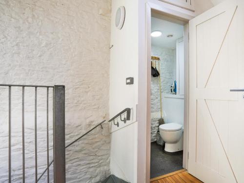 a bathroom with a door leading to a toilet at The Old Stables in Totnes