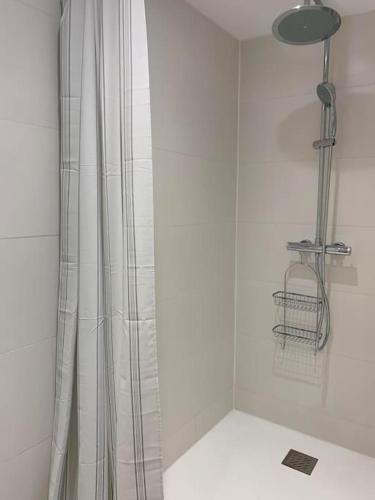 une douche avec un rideau de douche dans une salle de bain dans l'établissement Dune et Terrasse, à Merville-Franceville-Plage