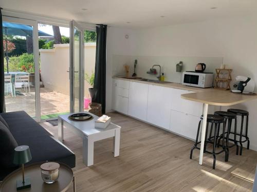 a kitchen and living room with a couch and a table at Dune et Terrasse in Merville-Franceville-Plage