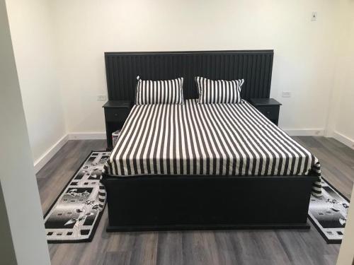 1 dormitorio con 1 cama con rayas blancas y negras en Lemmyalplace, en Georgetown
