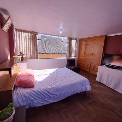ein Schlafzimmer mit einem Bett und einem großen Fenster in der Unterkunft Leonel in Puno