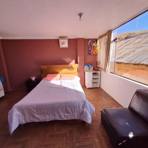 ein Schlafzimmer mit einem Bett, einem Stuhl und einem Fenster in der Unterkunft Leonel in Puno