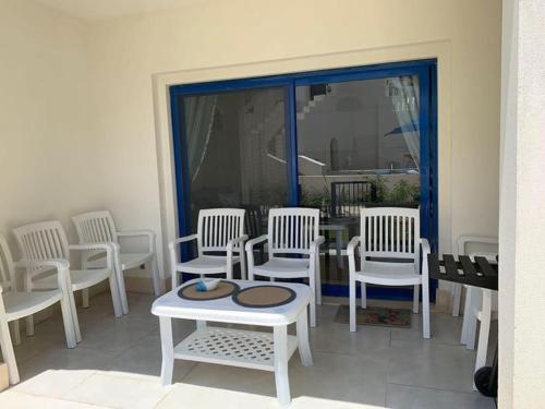 a room with white chairs and a table and a window at Marassi in El Alamein