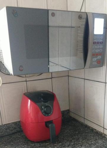 a kitchen with a microwave and a red appliance at TECH Hostel in Sao Paulo