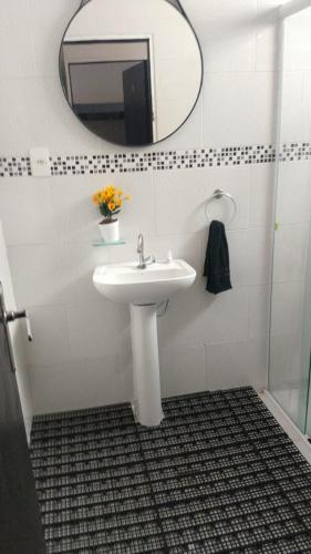 uma casa de banho com um lavatório e um espelho em TECH Hostel em São Paulo
