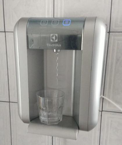 um dispensador de água com um copo dentro em TECH Hostel em São Paulo