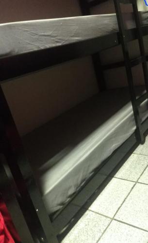 a metal bunk bed with the bottom shelf of it at TECH Hostel in Sao Paulo