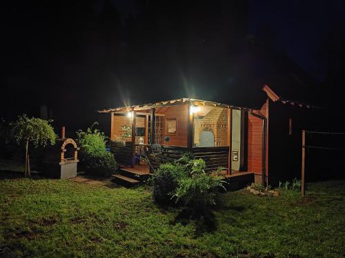 Una casita de noche con luces encendidas. en Klimatyczny domek w lesie przy jeziorze en Gietrzwałd