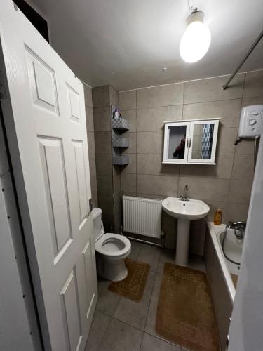 a bathroom with a toilet and a sink and a door at Quite apartment in Nottingham