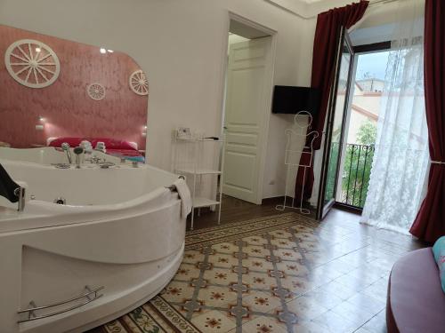 a large bathroom with a tub and a large window at Suite Inn Centro Dimora Storica in Enna