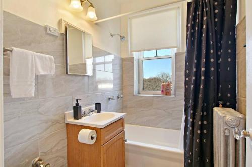 a bathroom with a sink and a tub and a shower at Inviting Studio Apartment in Evanston - Elmgate Manor 403 in Evanston