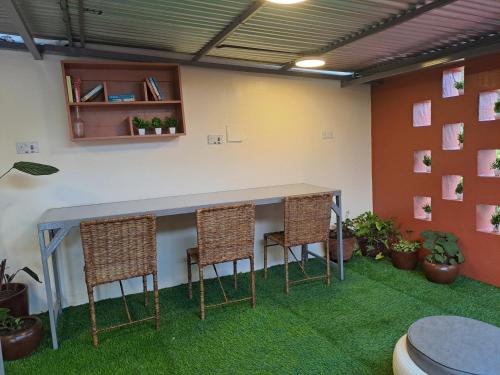 a table and chairs in a room with plants at The Yala Home in Eldoret