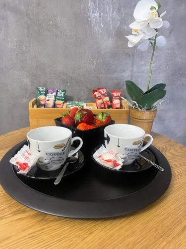 two cups and saucers on a table with fruit at Apartman Kis in Jajce