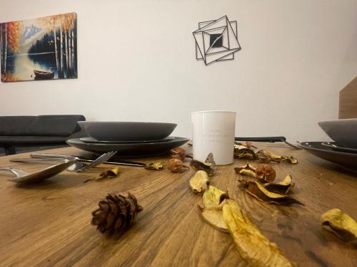 a table with leaves and a cup on top of it at Apartman Kis in Jajce
