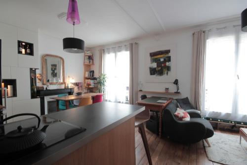 une cuisine et un salon avec une table et des chaises dans l'établissement 2 Pièces de charme Montmartre, à Paris