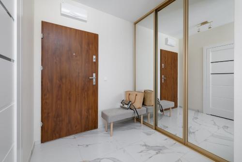 spogliatoio con porta in legno e sedia di TS Gold New Town Apartment & free private parking a Stettino