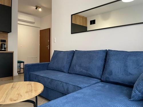 ein blaues Sofa im Wohnzimmer mit einem Tisch in der Unterkunft Twoja Przystań SŁAWA- Apartament przy plaży in Sława