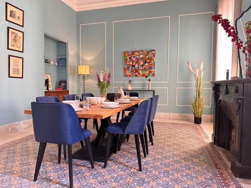 a dining room with a wooden table and blue chairs at Rooms in luxurious apartment in Old town of Tunis, near Medina in Tunis