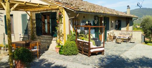 ein Haus mit einer Terrasse mit einem Tisch und Stühlen in der Unterkunft La Casa Tra Gli Ulivi in Cortona