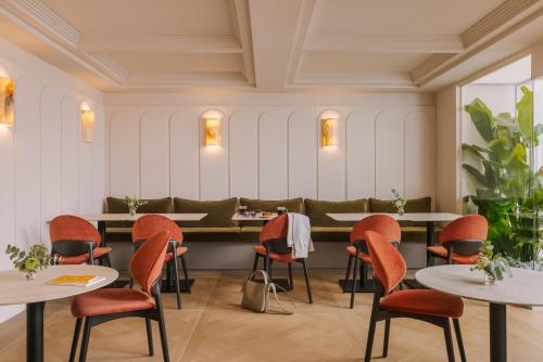 a restaurant with orange chairs and tables in a room at Yelo Mozart powered by Sonder in Nice