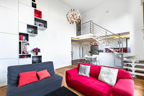- un salon avec un canapé rouge et un escalier dans l'établissement Confort et style Proche de Paris, à Asnières-sur-Seine