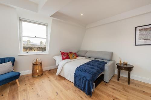 um quarto com uma cama, uma cadeira e uma janela em Bath Abbey View - City Centre em Bath