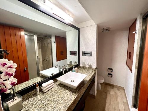 uma casa de banho com 2 lavatórios e um espelho grande em Spectacular Beach Romantic Sunset Lagoon View Studio em Cancún